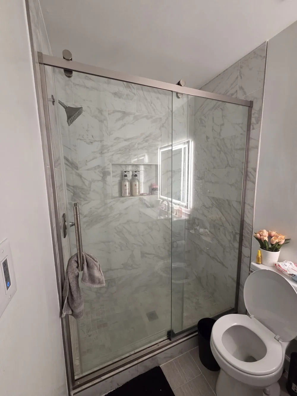 Ducha de baño renovada de lujo con azulejos de mármol
